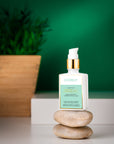 Skincare bottle with green label on a stone surface against a green background